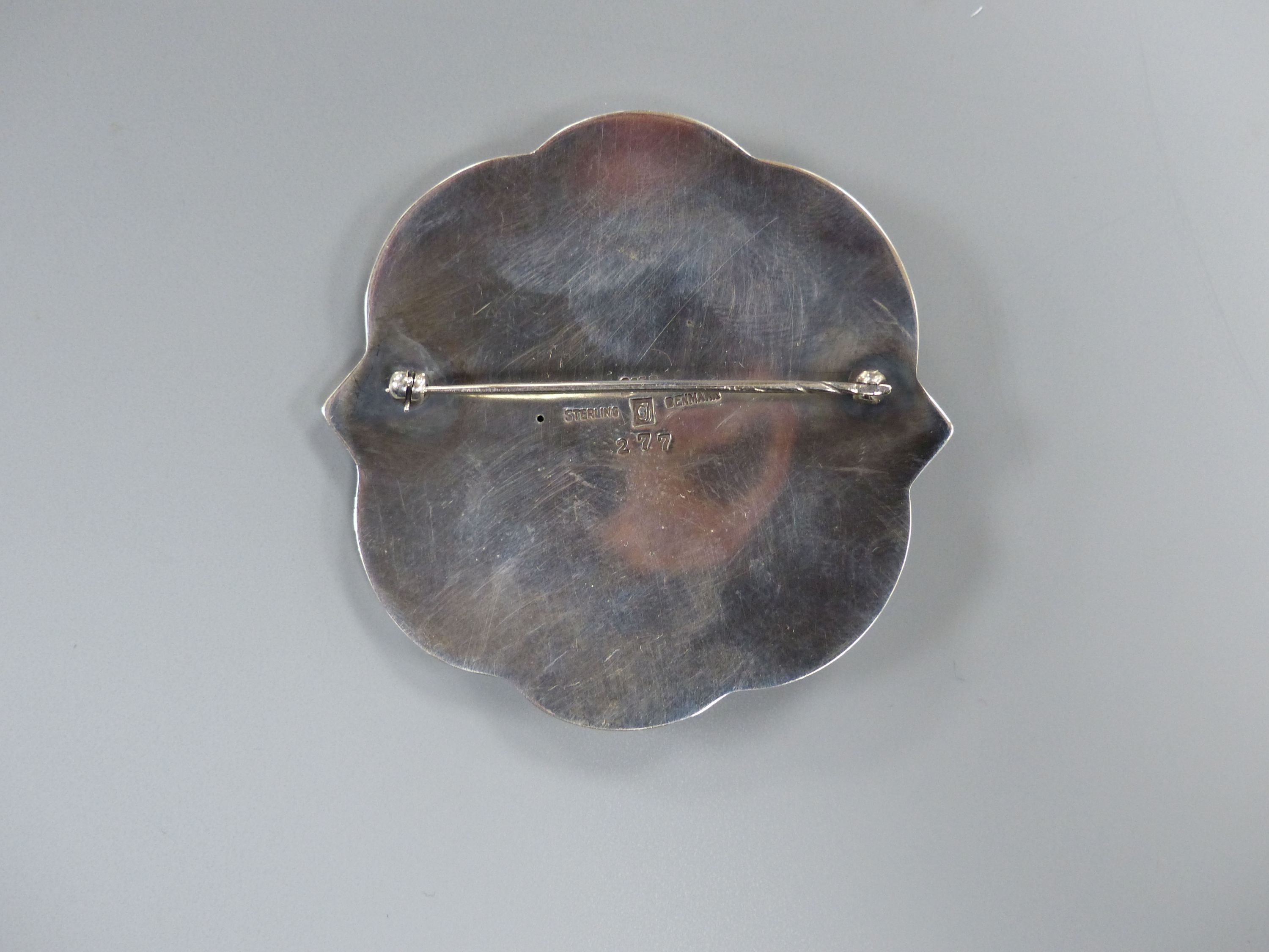 A George Jensen sterling shaped circular brooch, design no. 277 (Arno Malinowski?) depicting a mermaid on sea horse, 57mm.